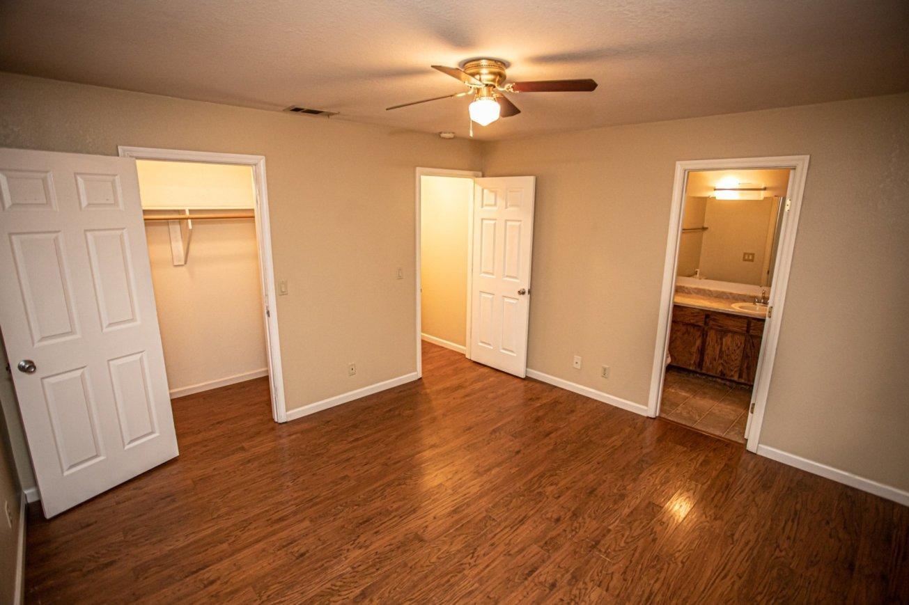 839 Springer Drive Redding, CA 96003 - Photo 4 of 10 an empty room with wooden floor and a ceiling fan