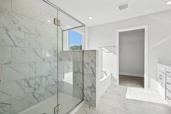 a bathroom with a glass shower door and a bathtub