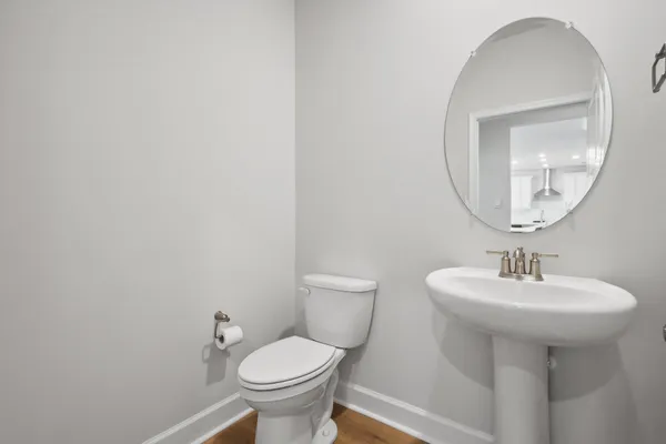 a bathroom with a sink toilet and a mirror