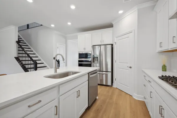a kitchen with stainless steel appliances kitchen island granite countertop a refrigerator and a sink
