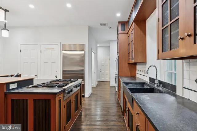 a view of a room with wooden floor staircase and a kitchen