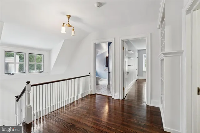 a view of a house next to a big yard and large trees