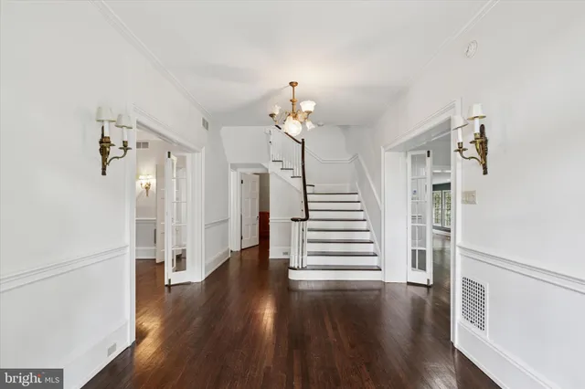 a view of an empty room with wooden floor fireplace and a window