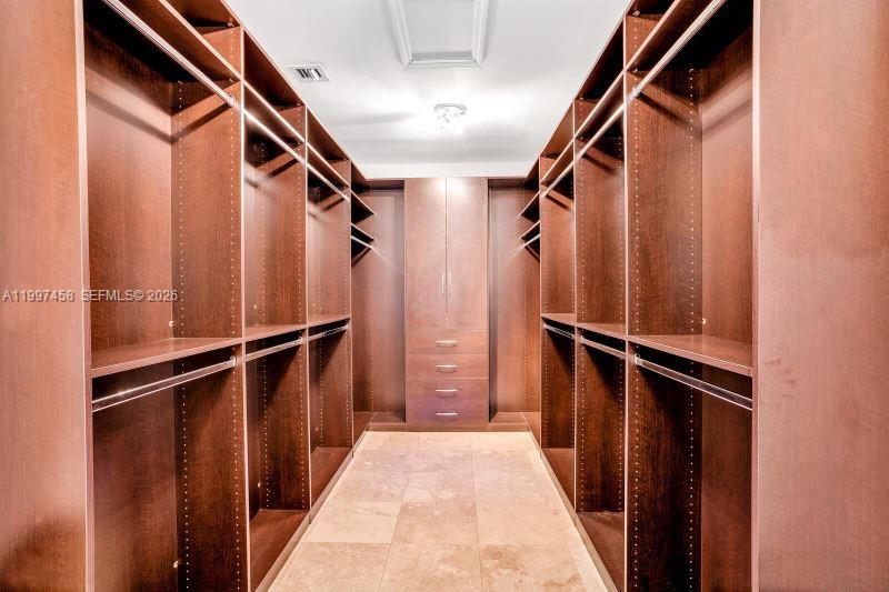 7405 Southwest 79th Court Miami, FL 33143 - Photo 20 of 29 a view of walk in closet with clothes and wooden floors
