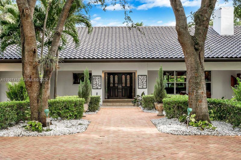 7405 Southwest 79th Court Miami, FL 33143 - Photo 2 of 29 a front view of a house with garden
