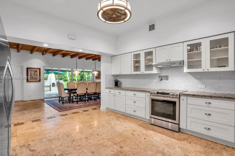 7405 Southwest 79th Court Miami, FL 33143 - Photo 23 of 29 a kitchen with stainless steel appliances granite countertop a stove and a sink with cabinets