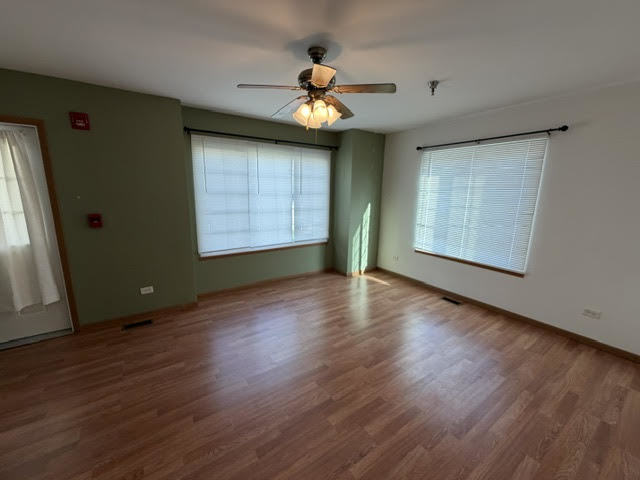 126 Washington Street, Unit A Ingleside, IL 60041 - Photo 5 of 9 a view of an empty room with wooden floor and a window