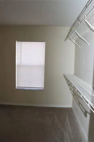 a view of a livingroom with an empty space and a window