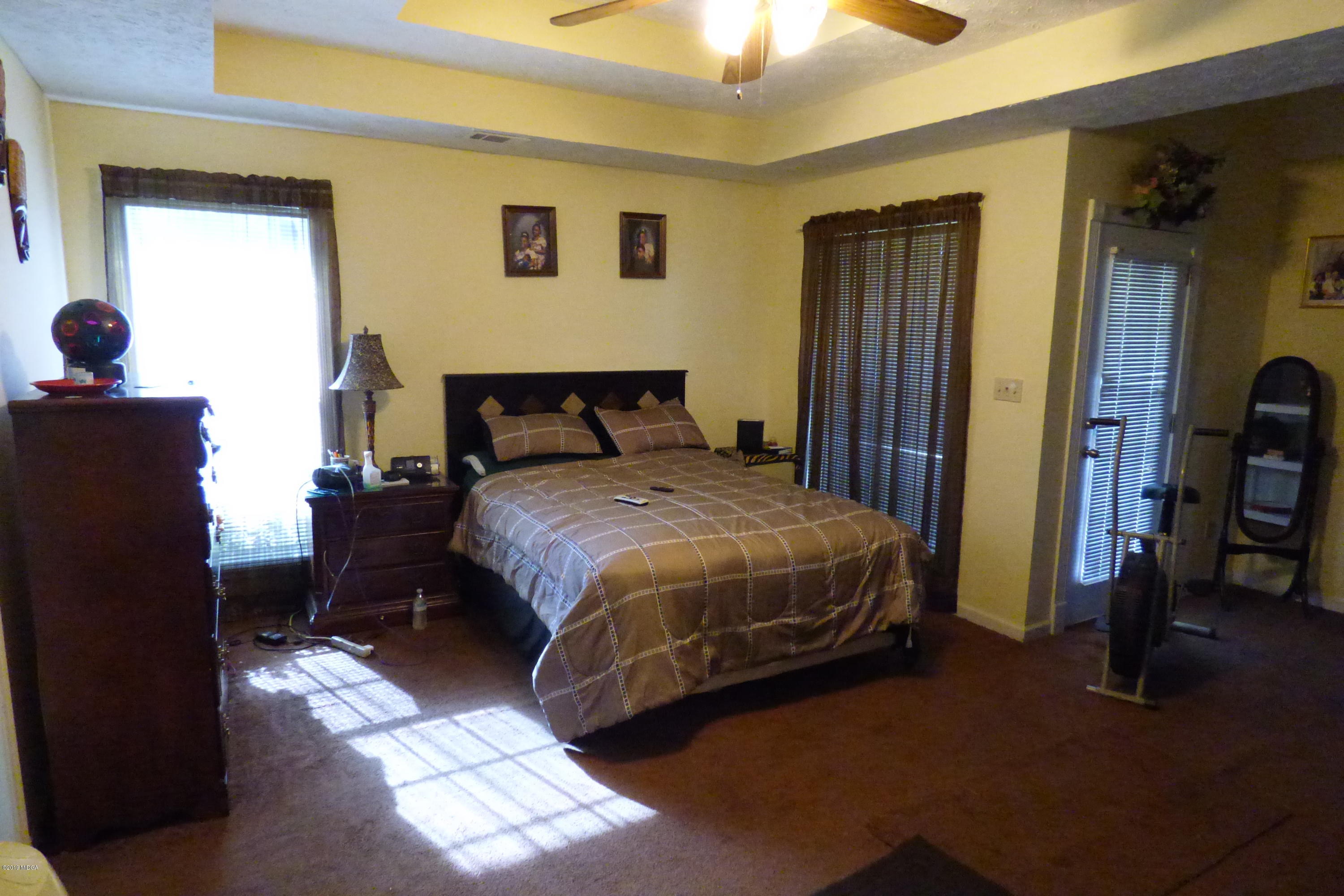 323 Rustin Road Reynolds, GA 31076 - Photo 21 of 25 a bedroom with a bed and a chandelier