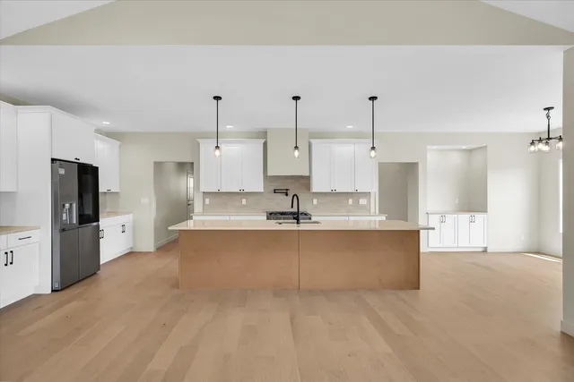 a kitchen with stainless steel appliances a stove a sink a oven a center island and cabinets