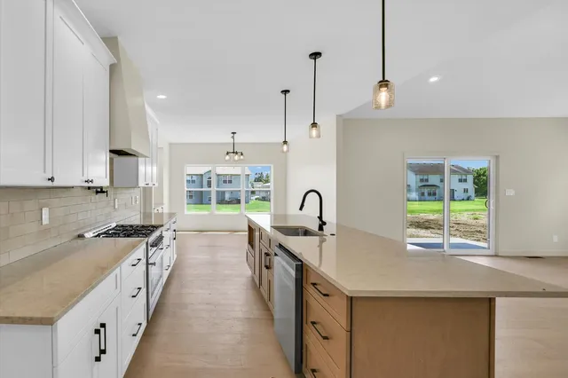 a kitchen with stainless steel appliances granite countertop a stove a sink and a refrigerator