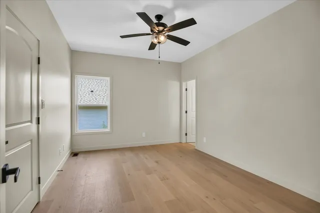 an empty room with closet and a chandelier fan