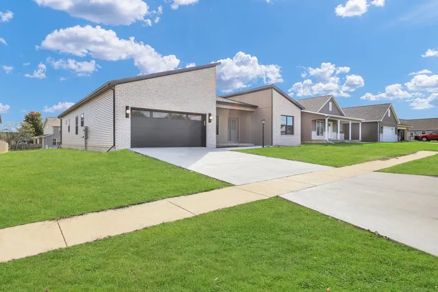 a front view of a house with a garden and yard