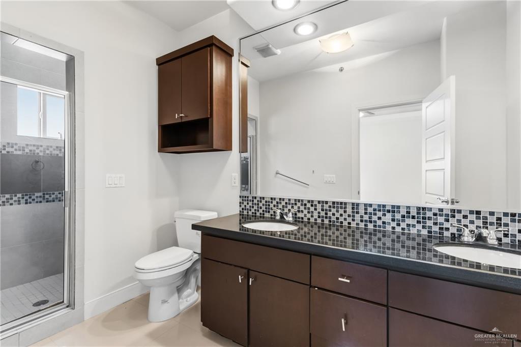 3016 South L Street, Unit 2 McAllen, TX 78503 - Photo 12 of 16 a bathroom with a sink a toilet and mirror
