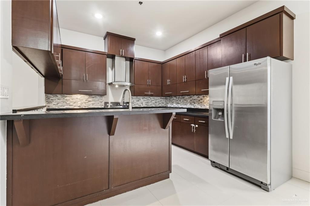 3016 South L Street, Unit 2 McAllen, TX 78503 - Photo 6 of 16 a kitchen with stainless steel appliances granite countertop a refrigerator and a sink