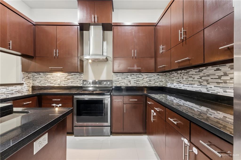 3016 South L Street, Unit 2 McAllen, TX 78503 - Photo 7 of 16 a kitchen with stainless steel appliances granite countertop a stove a sink and a microwave
