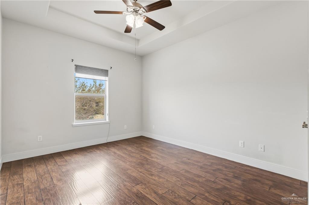 3016 South L Street, Unit 2 McAllen, TX 78503 - Photo 8 of 16 an empty room with wooden floor fan and windows