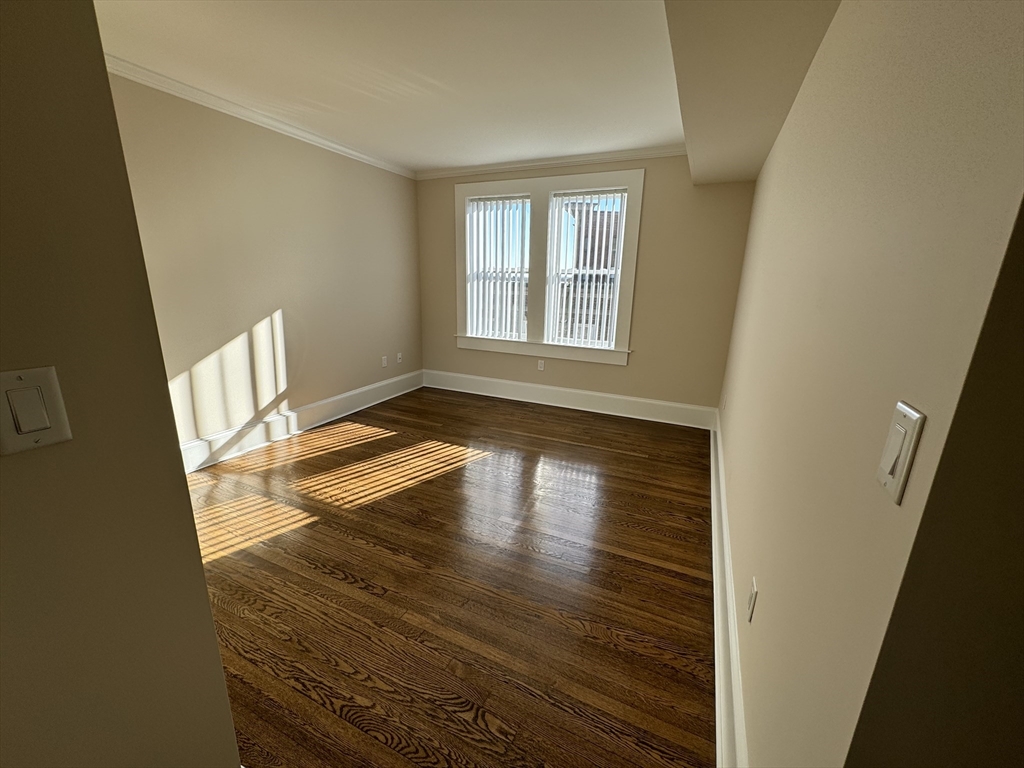 18 Short Street, Unit 3 Brookline, MA 02446 - Photo 13 of 14 a view of an empty room with wooden floor and a window