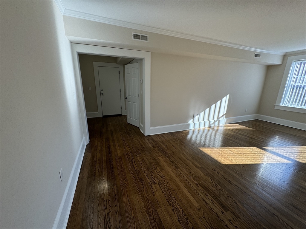 18 Short Street, Unit 3 Brookline, MA 02446 - Photo 3 of 14 a view of wooden floor in a hall with a window
