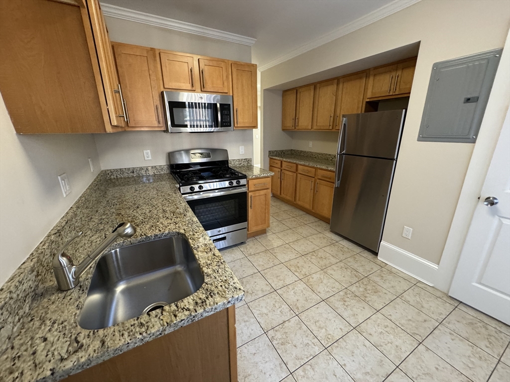 18 Short Street, Unit 3 Brookline, MA 02446 - Photo 6 of 14 a kitchen with granite countertop a refrigerator stove and microwave