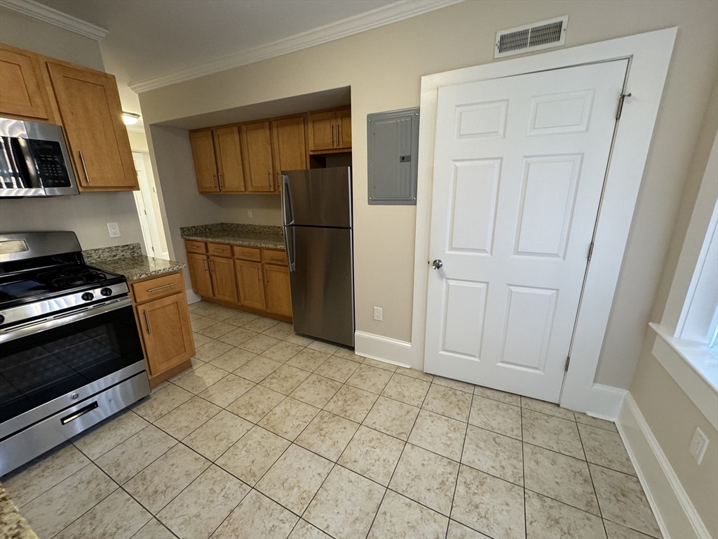18 Short Street, Unit 3 Brookline, MA 02446 - Photo 8 of 14 a kitchen with granite countertop a refrigerator and a stove top oven