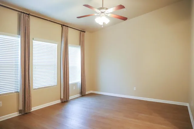 an empty room with closet and a chandelier fan