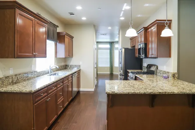 a large kitchen with kitchen island granite countertop a sink and a large cabinets