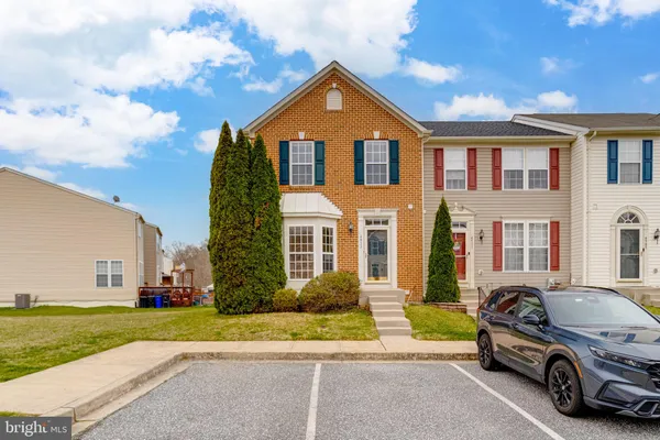 a car parked in front of a house with a yard