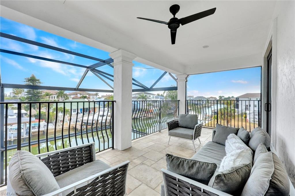 494 Seagull Avenue Naples, FL 34108 - Photo 12 of 32 a living room with furniture and a floor to ceiling window