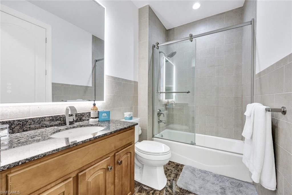 494 Seagull Avenue Naples, FL 34108 - Photo 16 of 32 a bathroom with a granite countertop sink toilet and shower