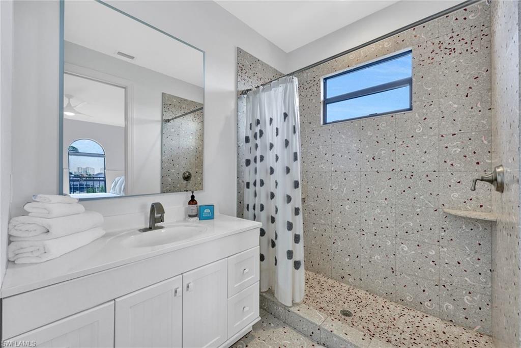 494 Seagull Avenue Naples, FL 34108 - Photo 18 of 32 a bathroom with a sink a mirror and a shower