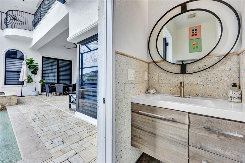 494 Seagull Avenue Naples, FL 34108 - Photo 20 of 32 a bathroom with a sink and a mirror