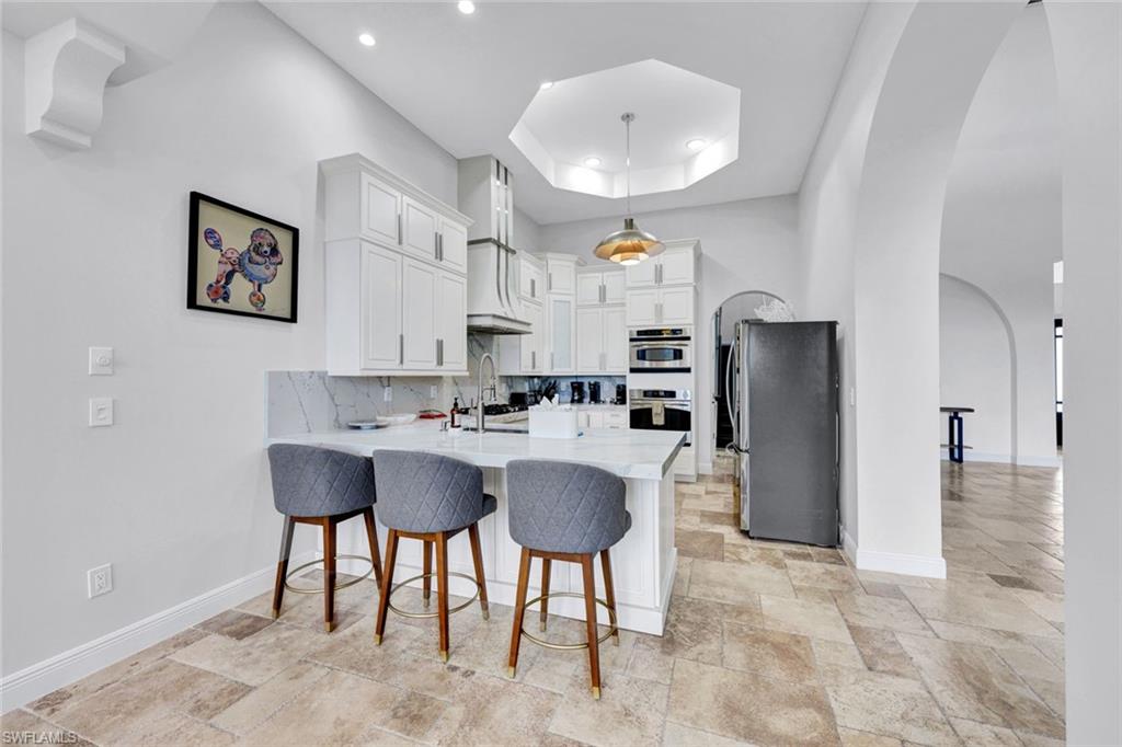494 Seagull Avenue Naples, FL 34108 - Photo 4 of 32 a living room with stainless steel appliances furniture a refrigerator and a dining table