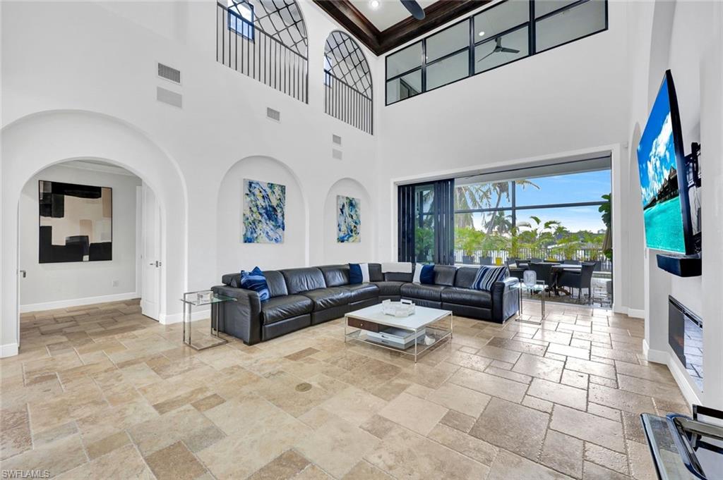 494 Seagull Avenue Naples, FL 34108 - Photo 6 of 32 a living room with patio furniture and a flat screen tv