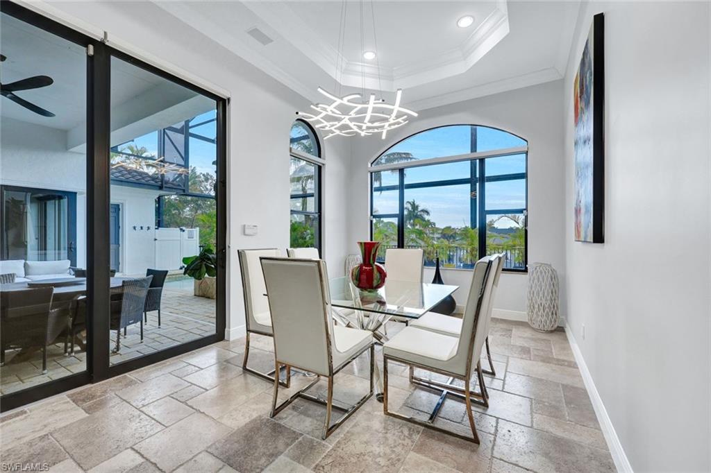 494 Seagull Avenue Naples, FL 34108 - Photo 7 of 32 a view of a dining room with furniture a chandelier and wooden floor