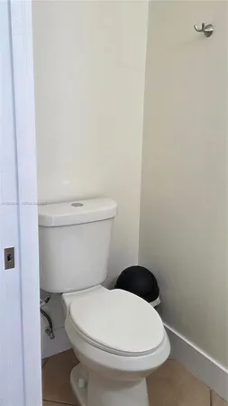 a white toilet sitting next to a white wall