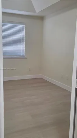 a view of a small space with wooden floor and a window
