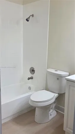 a white toilet sitting next to a bath tub