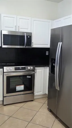 a kitchen with granite countertop a refrigerator and a stove