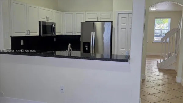 a view of kitchen with refrigerator and window