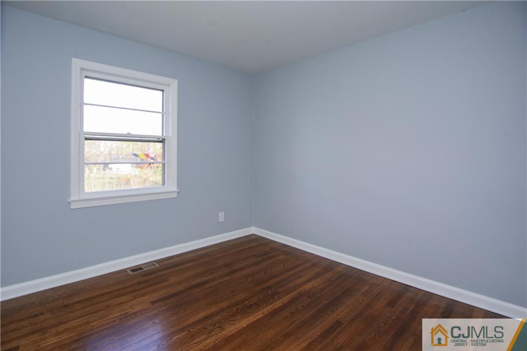 102 Magnolia Road Iselin, NJ 08830 - Photo 11 of 36 a view of an empty room with wooden floor and a window