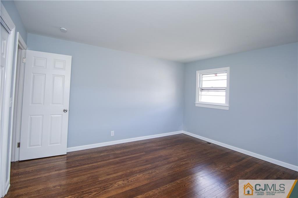 102 Magnolia Road Iselin, NJ 08830 - Photo 13 of 36 a view of an empty room with wooden floor and a window