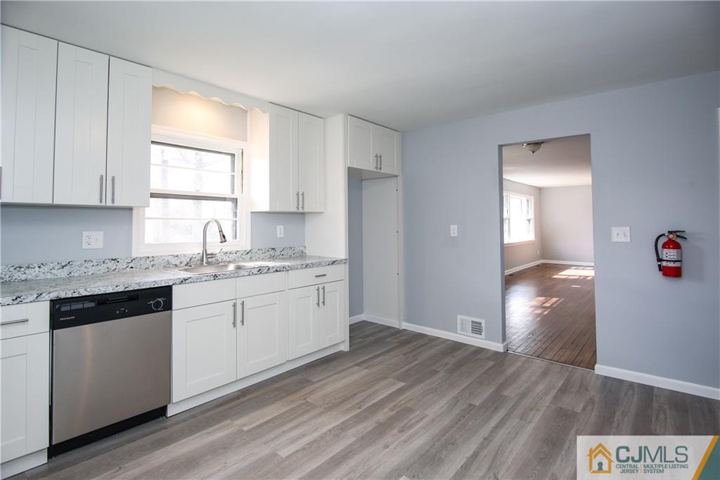 102 Magnolia Road Iselin, NJ 08830 - Photo 23 of 36 a kitchen with granite countertop white cabinets and white appliances