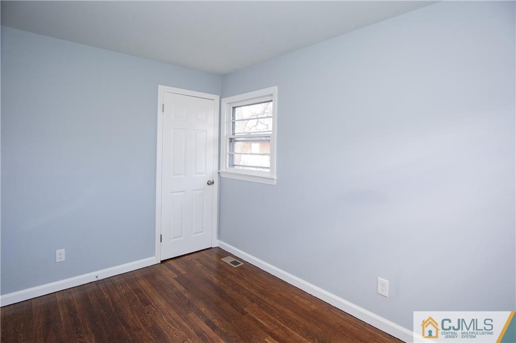 102 Magnolia Road Iselin, NJ 08830 - Photo 26 of 36 a view of an empty room with wooden floor and a window