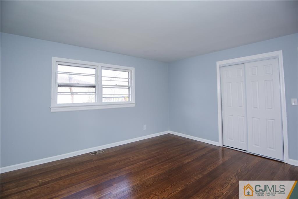 102 Magnolia Road Iselin, NJ 08830 - Photo 28 of 36 a view of an empty room with wooden floor and a window