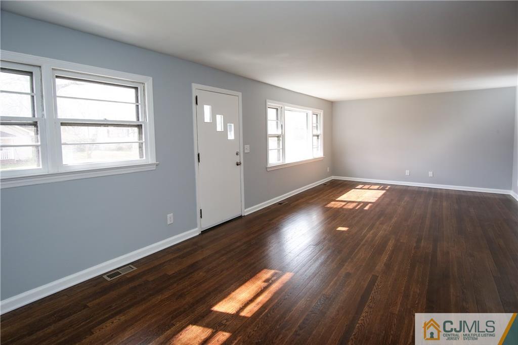 102 Magnolia Road Iselin, NJ 08830 - Photo 5 of 36 an empty room with wooden floor and windows