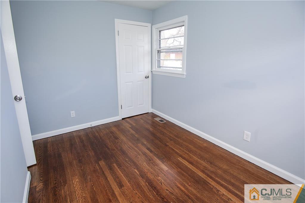 102 Magnolia Road Iselin, NJ 08830 - Photo 9 of 36 an empty room with wooden floor and windows