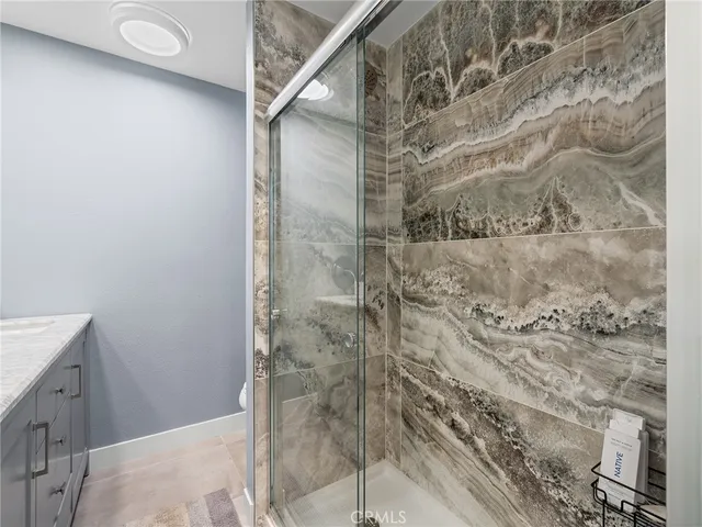 a bathroom with a granite countertop sink a shower and a mirror