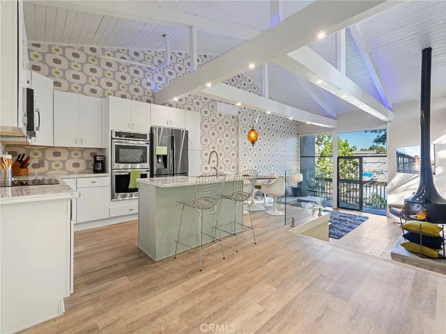 a kitchen with stainless steel appliances kitchen island granite countertop a stove a sink and a microwave