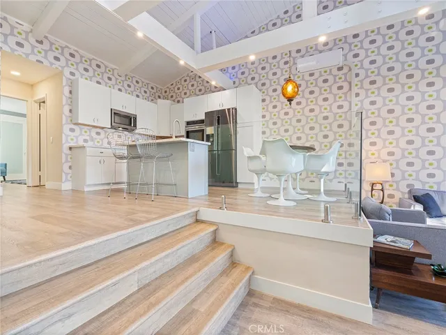 a living room with stainless steel appliances dining table and chairs